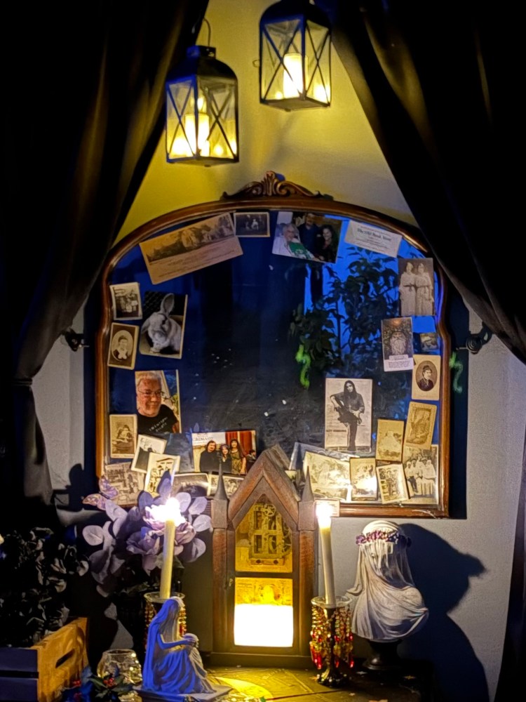 Decorative mirror with photos, candles, and hanging lanterns.