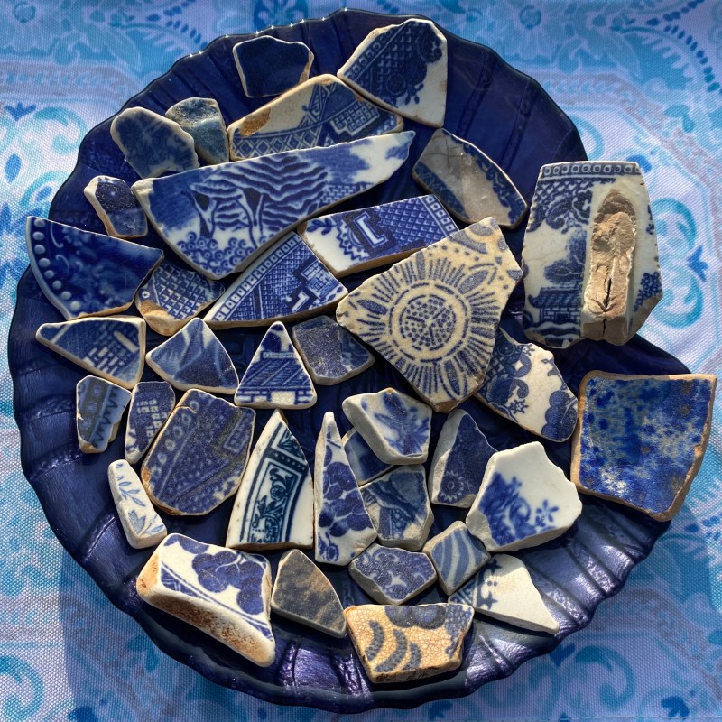 Blue ceramic shards arranged on a dark blue plate.