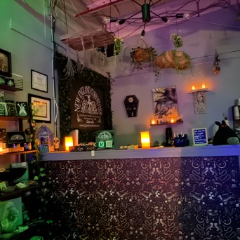 Cozy bar with dim lighting, decorative candles, and wall art.